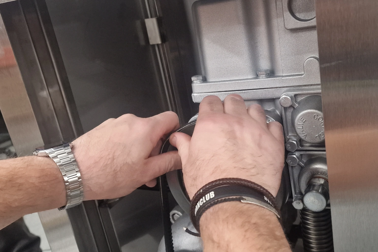 Hands inspecting components inside a fuel management unit